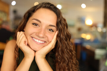 Portrait of a happy woman in a restaurant looking at you