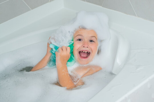 Children Bathing. Kid In A Bath Tub. Washing In Bath With Soap Suds On Hair. Child Taking Bath. Closeup Portrait Of Smiling Kid, Health Care And Kids Hygiene. Kids Face In Bath Tub With Foam.