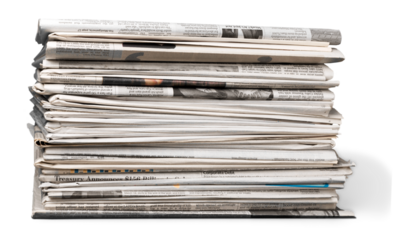 Pile of printed newspapers on white background