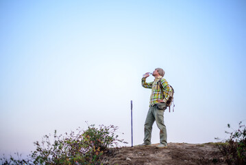 Portrait of Hiker man with backpack drinking water