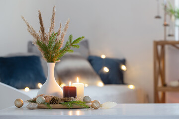 burning candles with christmas decor in white cozy interior