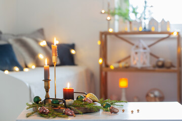 burning candles with christmas decor in white cozy interior
