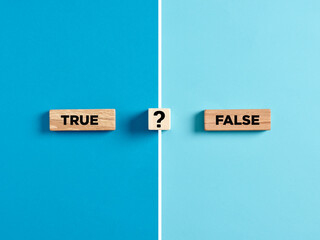 The words true and false on wooden blocks with question mark symbol. - obrazy, fototapety, plakaty