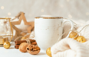 Cup of hot cocoa or coffee with fir tree, candle, wooden star and warm cozy sweater. Christmas greeting card, lights background. Xmas holiday eco nature decorations. Zero waste.