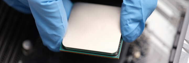 Technician examines microprocessor chip on PC motherboard