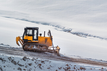 Heavy duty road building machinery bulldozer or earthmover on construction site on snowcovered hill in winter © Bits and Splits