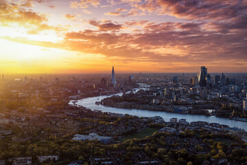 High panoramic view of the urban skyline of London, England, with the river Thames leading into the City disctrict and beyond during a beautiful sunset