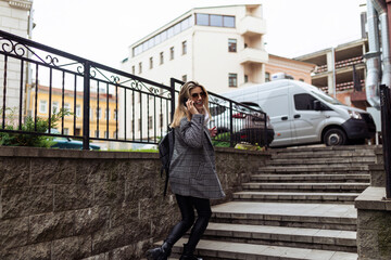 a woman climbs the stairs speaks on a mobile phone and turns around