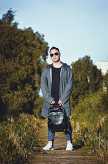 person with backpack walking in the park