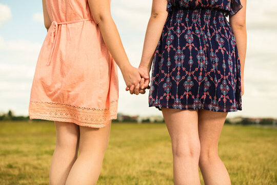 Two young women walking hand in hand, close-up
