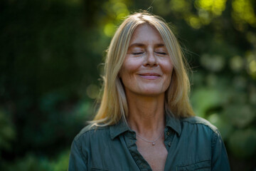 Smiling mature woman with eyes closed in garden