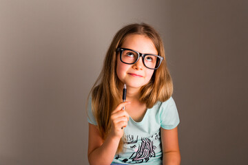 Portrait of smart girl with oversized glasses thinking