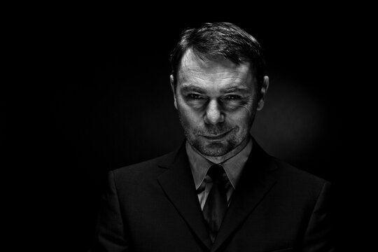 Portrait of mature man against black background, close up