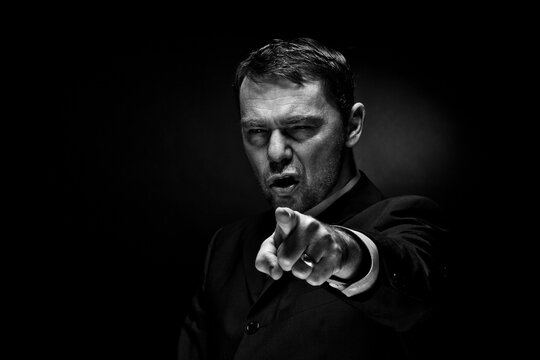 Portrait of mature man against black background, close up