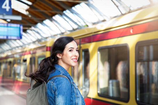 Germany, Berlin, young woman waiting in front of city train