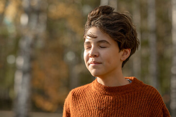 Boy with eyes closed in park