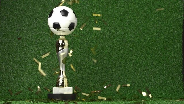 Soccer champion trophy revolves around itself with falling golden confetti. Video 4K