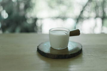 Fresh milk in a shot glass for ingredients to making drinks put on wood table