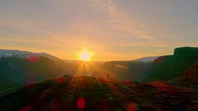 Aerial drone shot flying over mountain top revealing beautiful scenery of Aurland, Norway at sunrise.