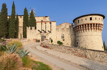 Fototapeta na wymiar Entrance to the castle of Brescia town with drawbridge and Tower of Prisoners (Torre dei Prigionieri) Lombardy, Italy