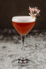 Delicious red cocktail with foam on the black background