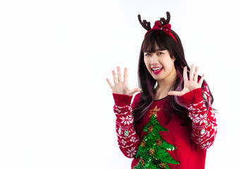 Merry Christmas. Asian woman wearing reindeer horns headband red sweater looking camera white background.
