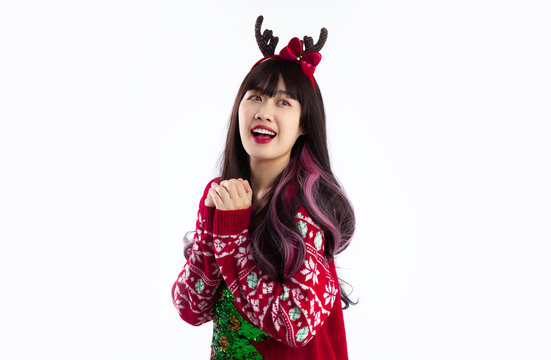 Young asian woman wearing reindeer horns headband red sweater posing on white background. Merry Christmas.
