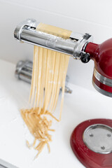 raw pasta maker robot cut spaghetti  handmade white background