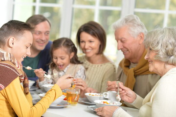 Happy family of different generations eating together 