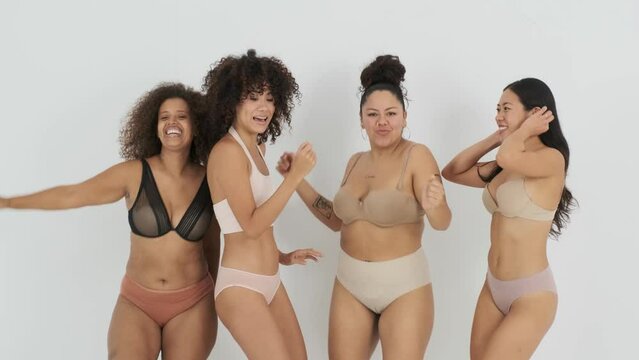 Delighted young body positive multiethnic female models dancing in studio