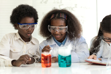 Group of teenage student learn with teacher and study doing a chemical experiment and holding test tube in hand in the experiment laboratory class on table at school.Education concept - Powered by Adobe