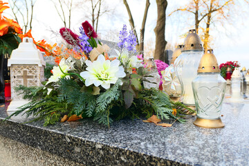 Flowers and candles on the grave at cemetery. All the Saints Day holiday