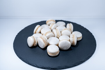 Fototapeta na wymiar White vanilla macarons, black dish, french dessert