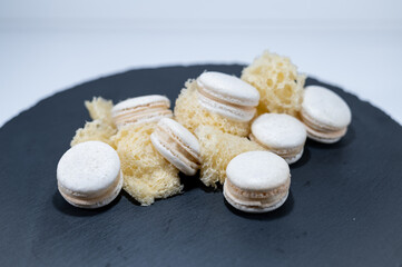 White vanilla macarons, sponge mousse cake, black dish, french dessert