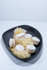 White vanilla macarons, sponge mousse cake, black dish, french dessert