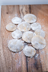 Obraz na płótnie Canvas fresh raw pasta handmade uncooked raviolis wood table flour
