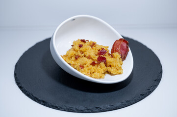 yellow risotto bacon shell white black closeup 