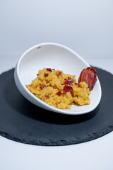 yellow risotto bacon shell white black closeup 