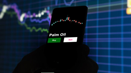 An investor's analyzing the Palm Oil etf fund on screen. A phone shows the ETF's prices stocks to invest