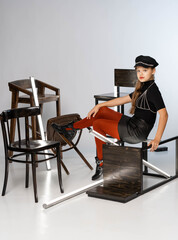 Studio shooting Girl in red pantyhose sits on a chair