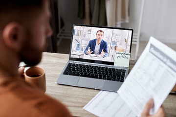 Selective focus on laptop screen with confident male tutor in formalwear explaining grammar rules...