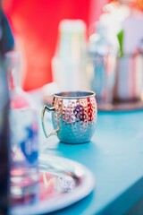 Shallow focus of a silver mule mug on a blurred table