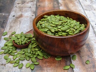 Green pumpkin seeds in a wooden bowl 