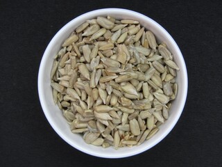 Peeled Sunflower Seeds in a bowl on black background 