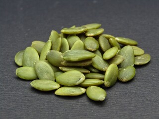 Green pumpkin seeds on black background 