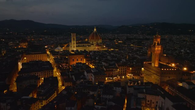 Breath taking night aerial panoramic footage of illuminated sights in historic city centre. Florence, Italy