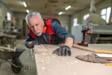 Carpenter carving wood in a workshop