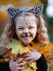 The little girl plays in the park in the fall