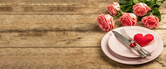 Romantic dinner table on rustic background. Love cutlery for Valentine's or Mother's day, Wedding