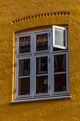 Copenhagen, Denmark An open window on a yellow facade in Christianshavn.